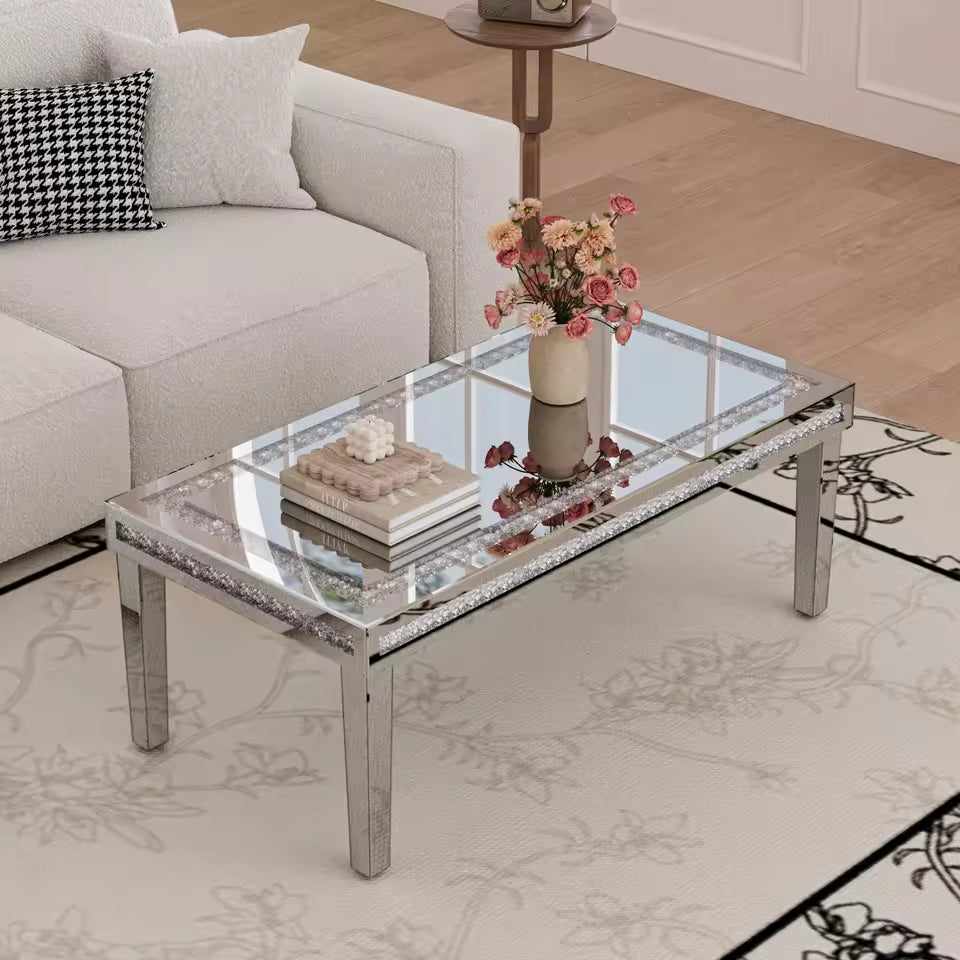 A rectangular mirrored coffee table with a crystal diamond inlay around its edges, set in front of a light gray sofa.