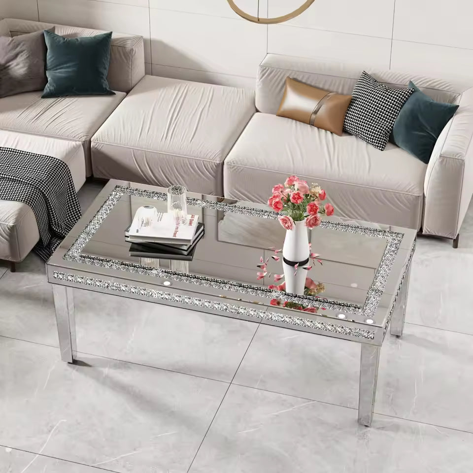 Rectangular mirrored coffee table with crystal crushed diamond inlay border in a living room.