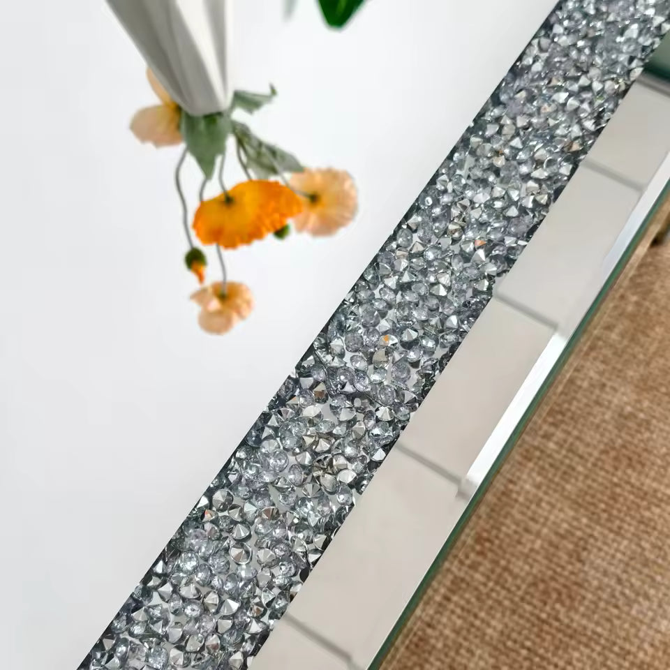 Close-up of a mirrored tabletop with crushed crystal diamond inlay and reflection of flowers.