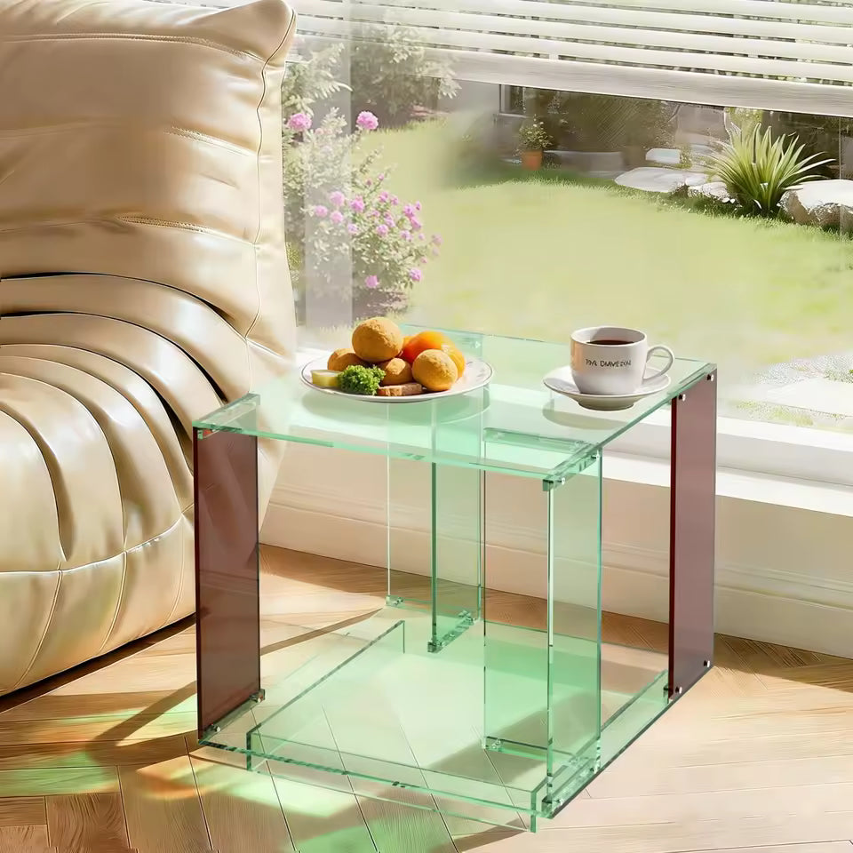 Two-tier green tinted acrylic end table with brown legs, holding snacks and a coffee cup by a window.