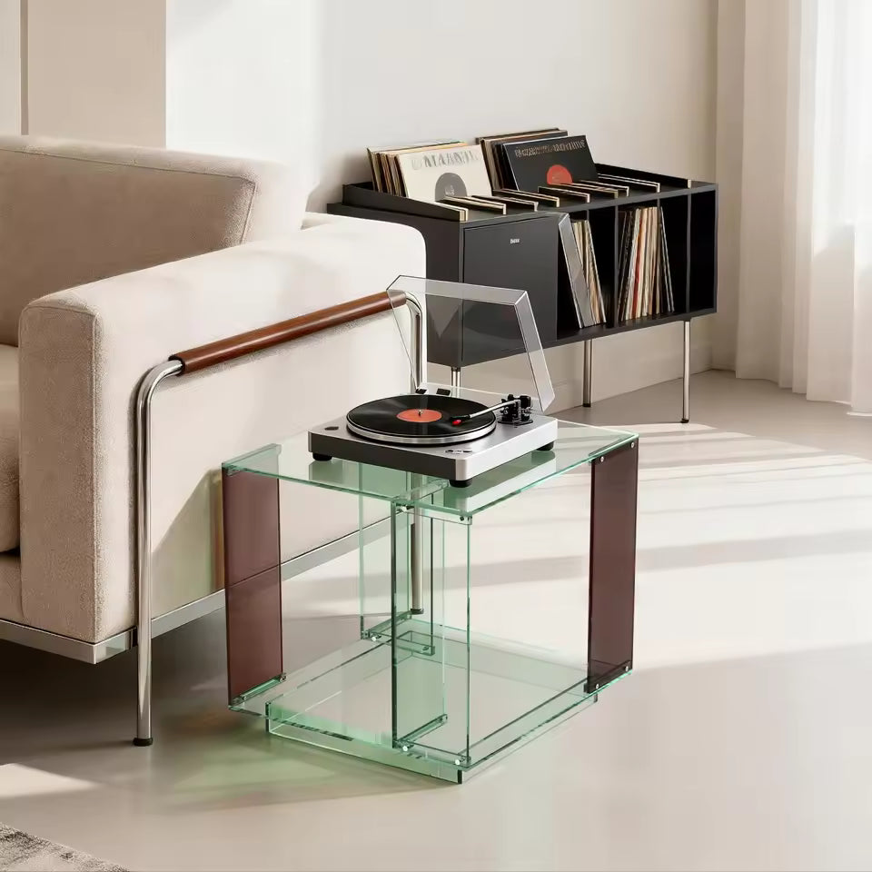 Green-tinted acrylic two-tier end table holding a record player next to a sofa.