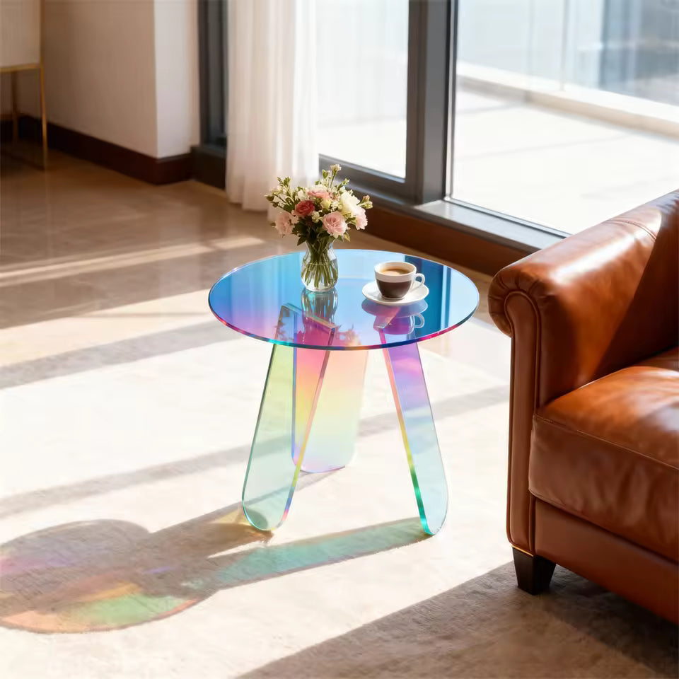 Round iridescent rainbow acrylic side table with flowers and coffee, next to a leather couch.