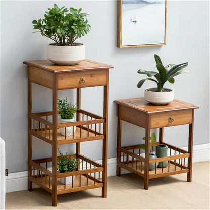 Bamboo side tables with drawers and open slatted shelves, displaying potted houseplants.