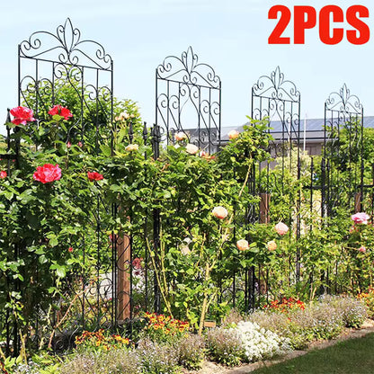 Two tall decorative black metal garden trellises with climbing rose bushes in full bloom.