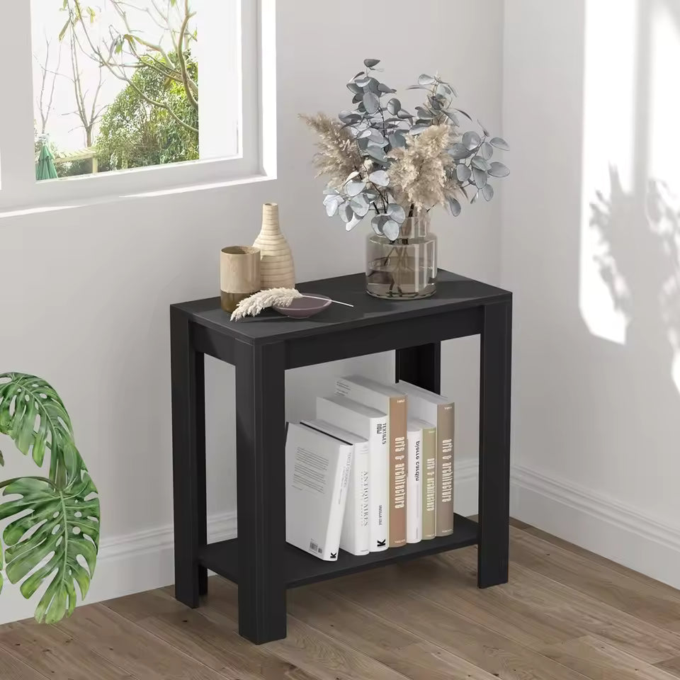 Black 2-tier side table holding decorative vases on top and books on the bottom shelf.