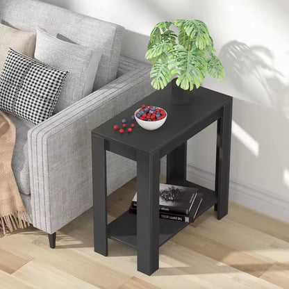 Modern black narrow side table next to a sofa, with a potted plant, fruit bowl, and books.