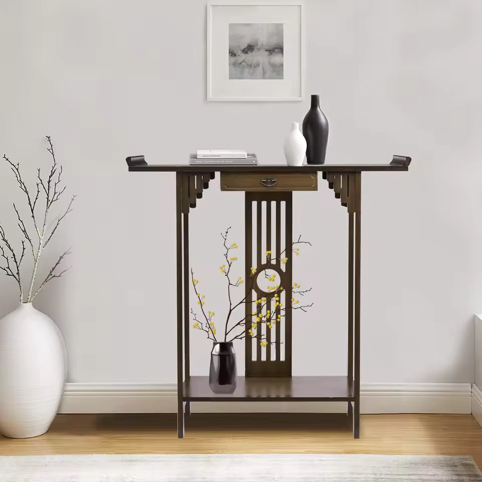 Dark wood Chinese-style console table with upturned ends, styled with vases and books.