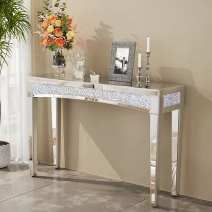 Silver mirrored console table with a crushed diamond inlay strip, flowers, photo frame, and candles.