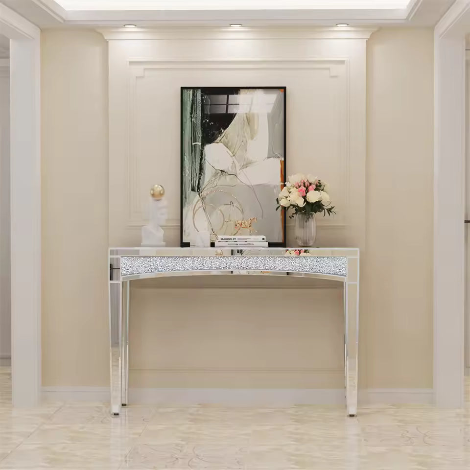Modern silver mirrored console table with crushed diamond inlay and decor in a beige entryway hallway.