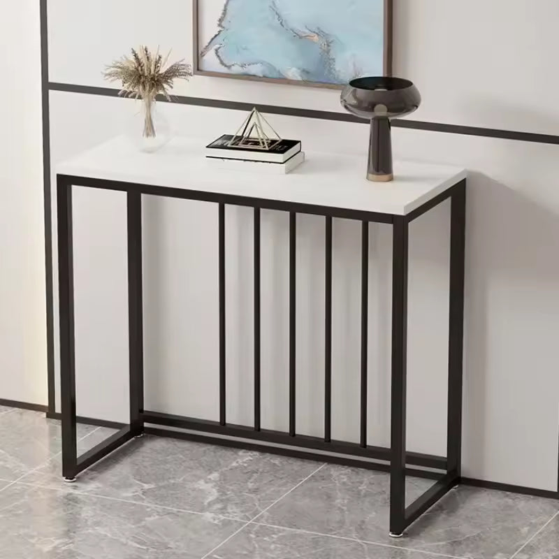 Modern narrow white console table with a black metal frame and vertical slats holding decor items.
