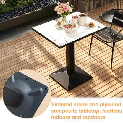 Square marble-patterned bistro table on an outdoor deck, set with breakfast and flowers.