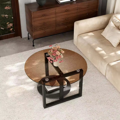 Round amber-tinted glass coffee table with black metal legs and bottom shelf in a modern living room.