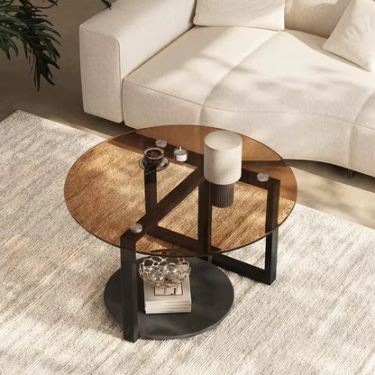 Round amber glass coffee table with a lower stone storage shelf and black metal frame.