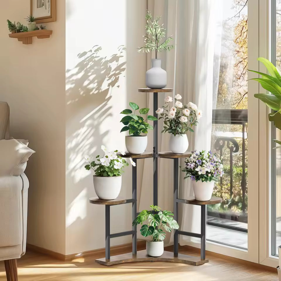 Tall multi-tier corner plant stand displaying white potted plants in a sunlit room.