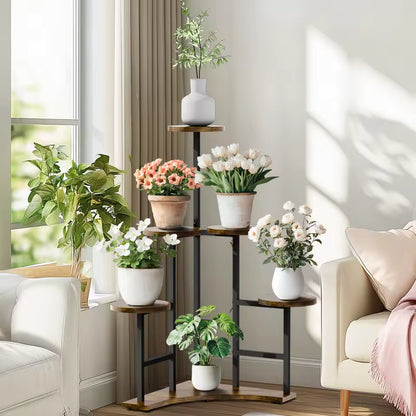 Multi-tiered corner plant stand holding various potted flowers and plants next to a window.