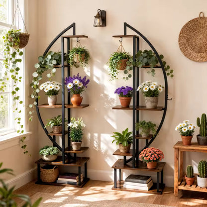 Two half-moon tiered plant stands with black metal frames filled with potted plants and flowers.