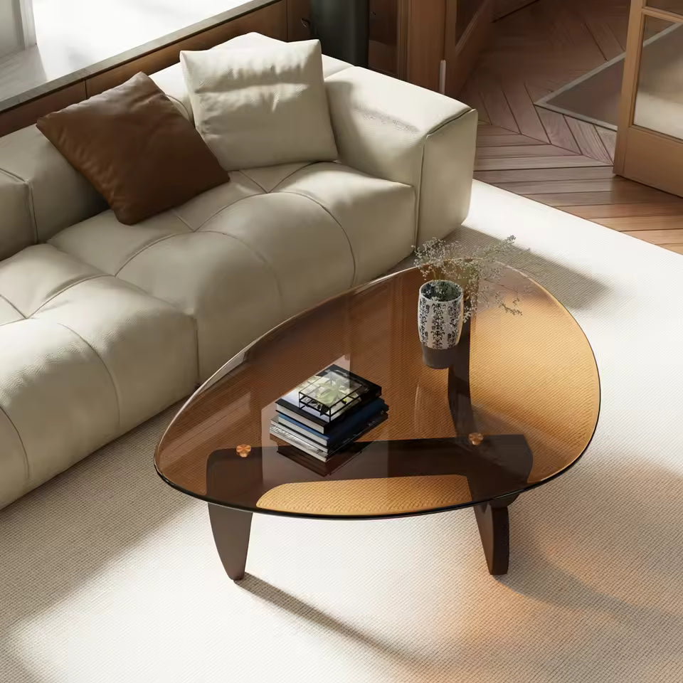 Mid-century modern triangular coffee table with amber-tinted glass top and dark wooden legs.