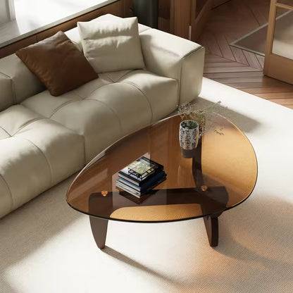 Mid-century modern triangular coffee table with amber-tinted glass top and dark wooden legs.