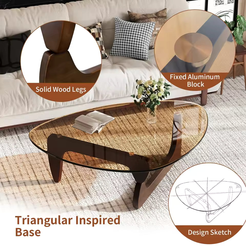 Mid-century triangular coffee table with amber glass top and solid wood legs in a living room.