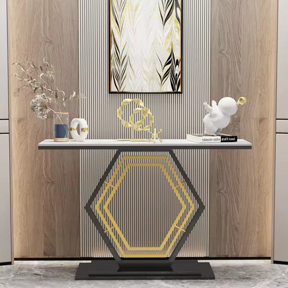 Modern console table with a geometric black and gold base and decorative objects on top.