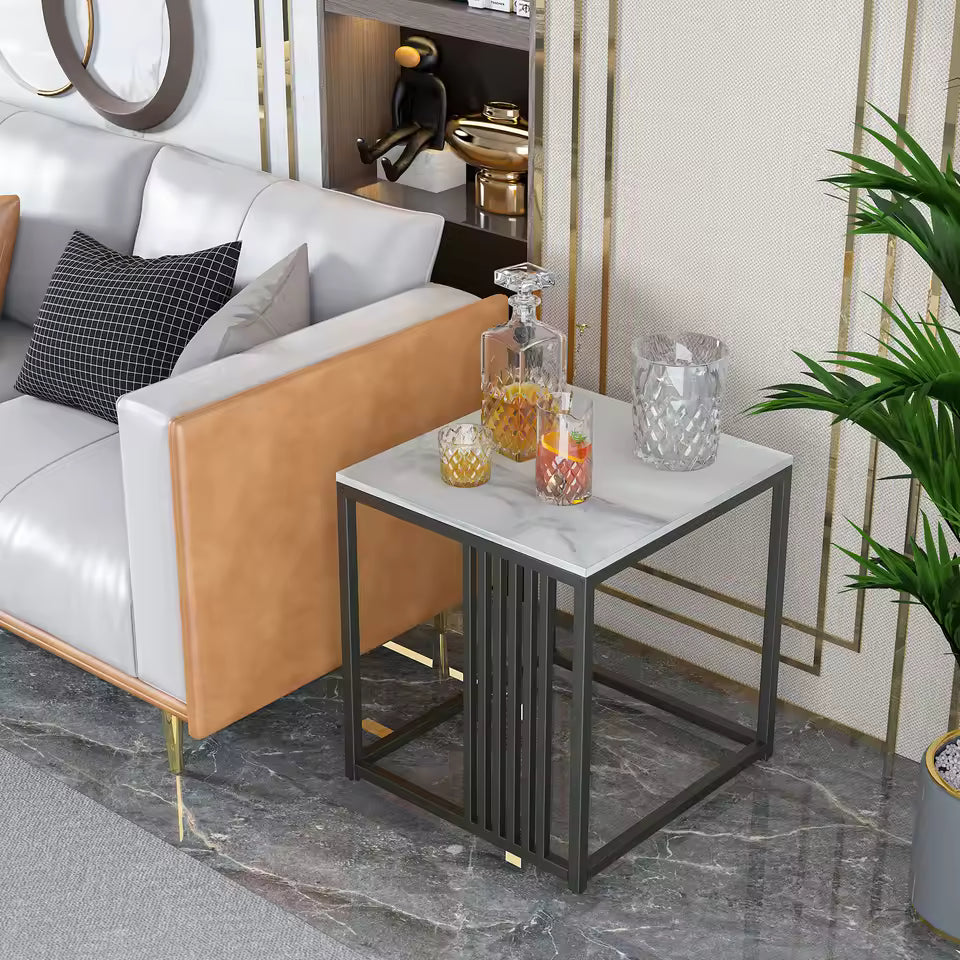 White marble top side table with a dark metal frame, holding glassware next to a sofa.
