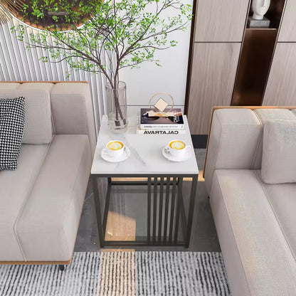 White marble-top end table with dark metal legs between sofas, holding coffee cups and a tall vase.