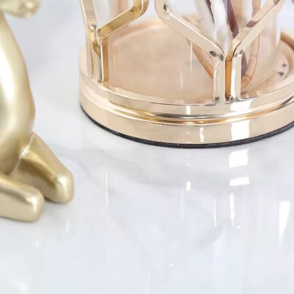 Close-up of a white marble tabletop with gold metal decorative objects resting on its surface.